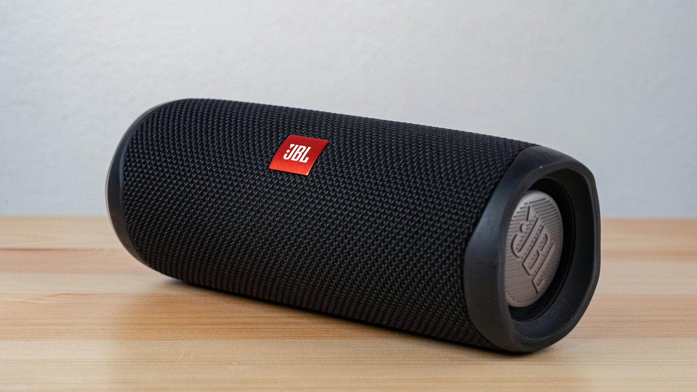 A portable Bluetooth speaker resting on a wooden surface